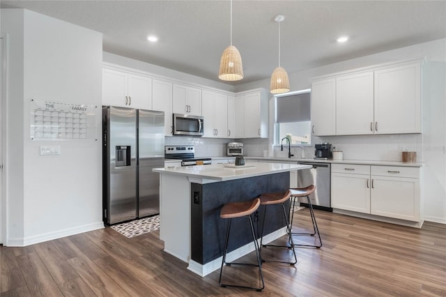 kitchen with hardwood / wood-style flooring, stainless steel appliances, and white cabinets