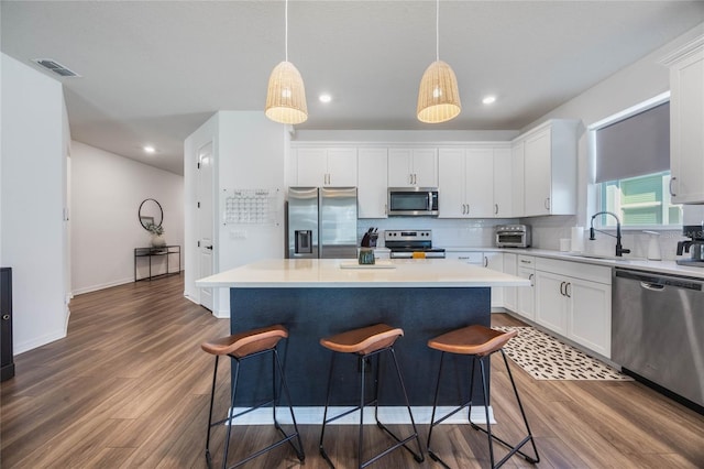 kitchen featuring stainless steel appliances, white cabinetry, and a kitchen island