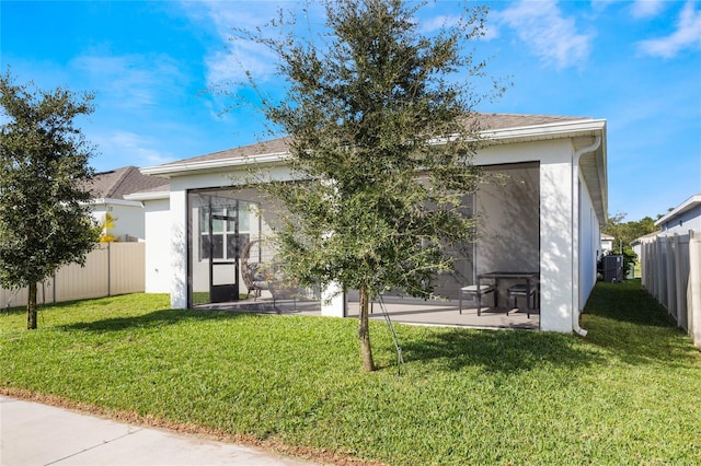 rear view of property with a lawn and a patio area