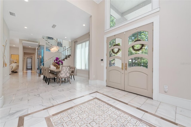 foyer entrance featuring french doors and a high ceiling