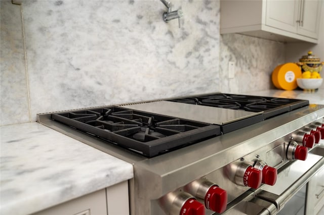 kitchen featuring white cabinetry and stainless steel stove