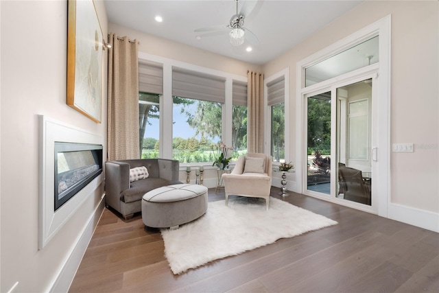 living area with hardwood / wood-style flooring, plenty of natural light, and ceiling fan