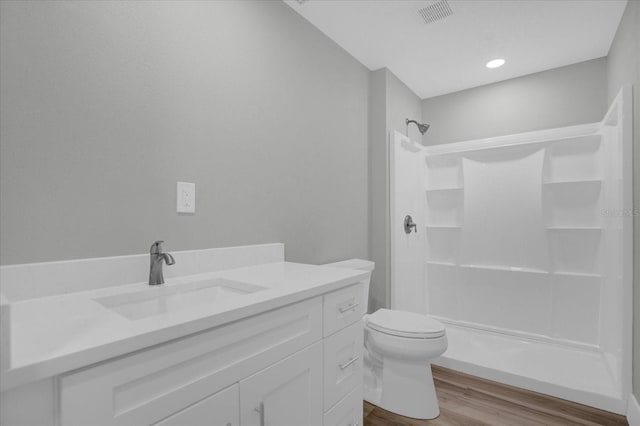 bathroom with walk in shower, vanity, toilet, and hardwood / wood-style flooring