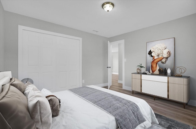 bedroom with dark hardwood / wood-style flooring and a closet