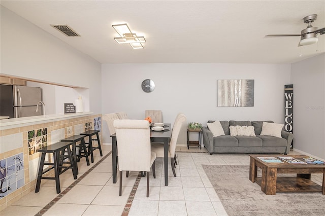 tiled dining space with ceiling fan