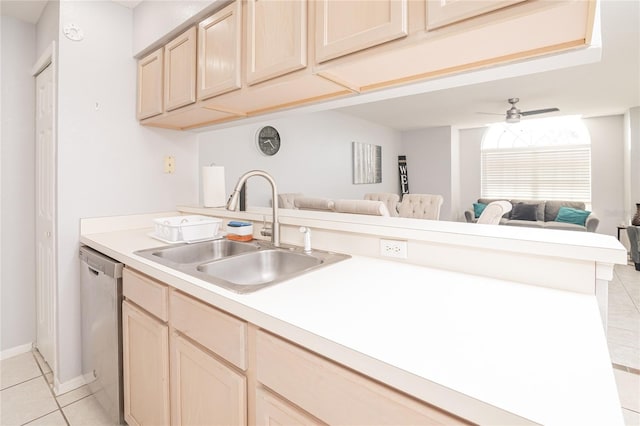 kitchen featuring stainless steel dishwasher, light brown cabinetry, light tile patterned floors, and sink