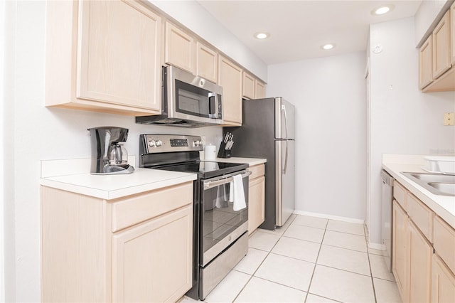 kitchen with light brown cabinetry, appliances with stainless steel finishes, and light tile patterned floors