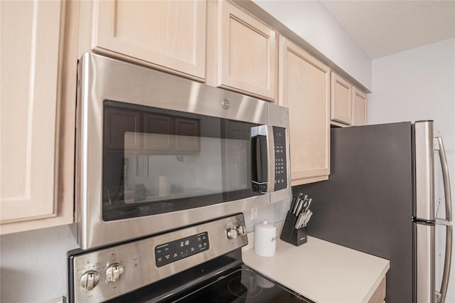 kitchen with light brown cabinets and appliances with stainless steel finishes