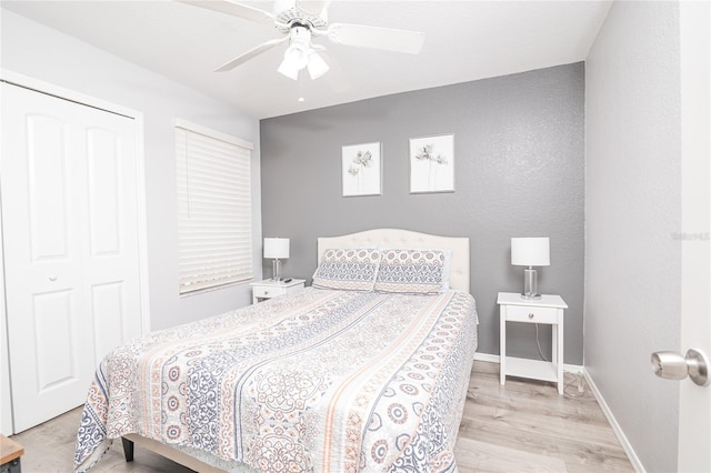 bedroom with light hardwood / wood-style floors, ceiling fan, and a closet