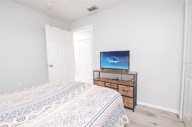 bedroom with light wood-type flooring and a closet