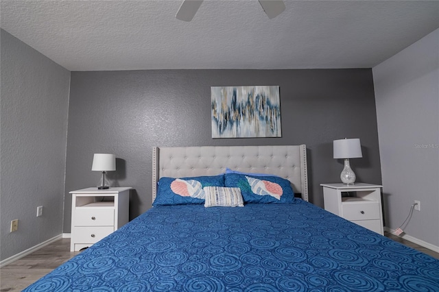 bedroom featuring wood-type flooring, ceiling fan, and a textured ceiling