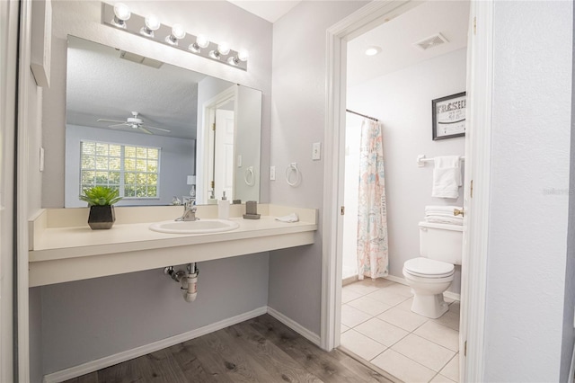 bathroom featuring a textured ceiling, hardwood / wood-style flooring, a shower with shower curtain, ceiling fan, and toilet