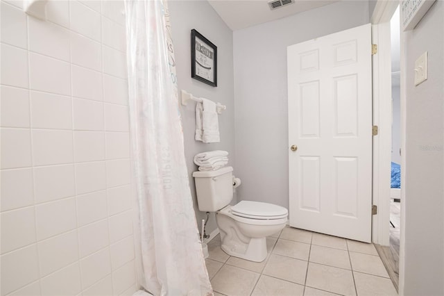 bathroom featuring tile patterned flooring, walk in shower, and toilet