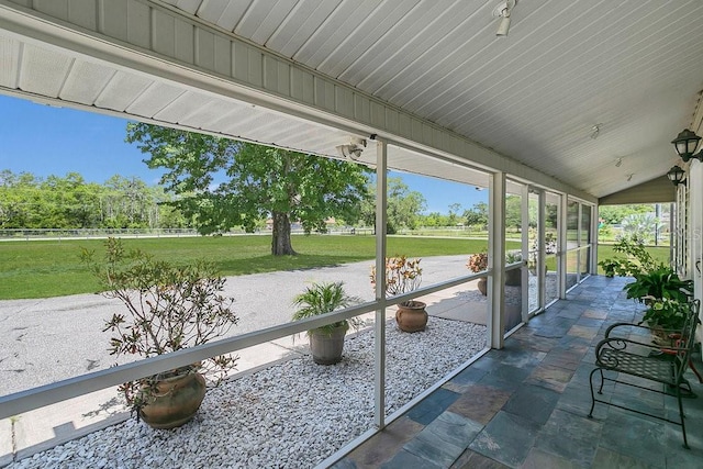 unfurnished sunroom featuring lofted ceiling