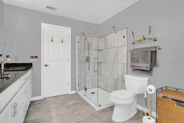 bathroom with walk in shower, vanity, and toilet