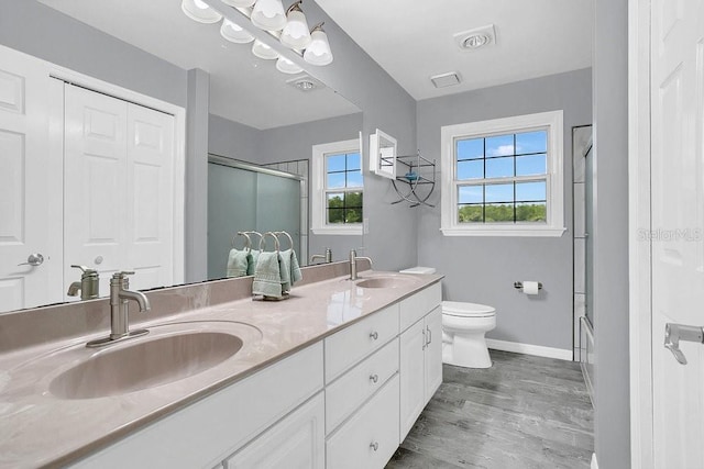 bathroom with wood-type flooring, vanity, and toilet