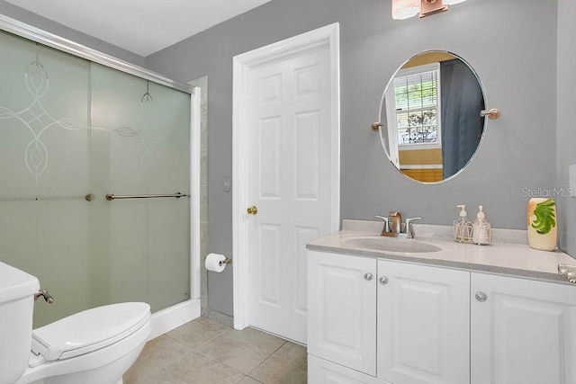 bathroom with vanity, a shower with shower door, toilet, and tile patterned flooring