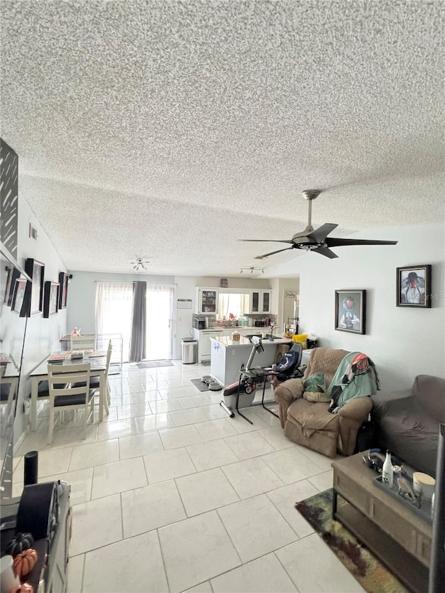 tiled living room with ceiling fan and a textured ceiling