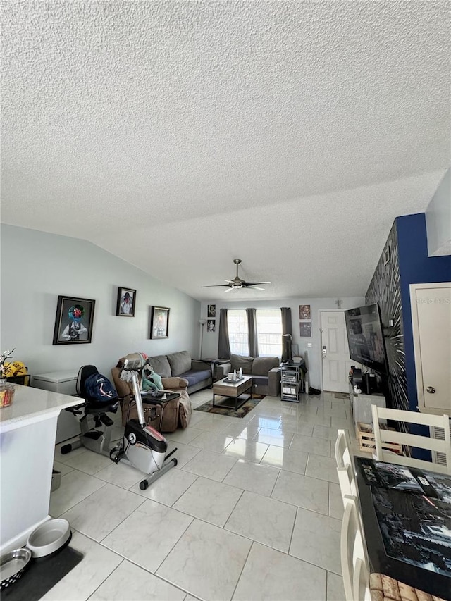 tiled living room featuring vaulted ceiling, ceiling fan, and a textured ceiling