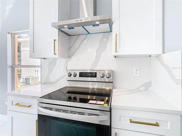 kitchen with electric range, white cabinetry, tasteful backsplash, and exhaust hood