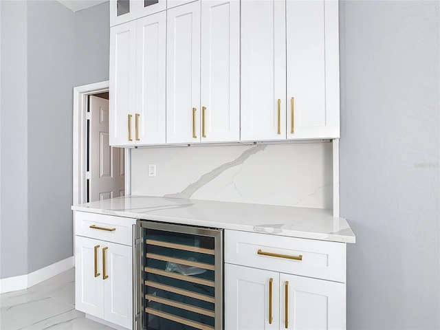 bar with white cabinetry, light stone counters, decorative backsplash, and beverage cooler