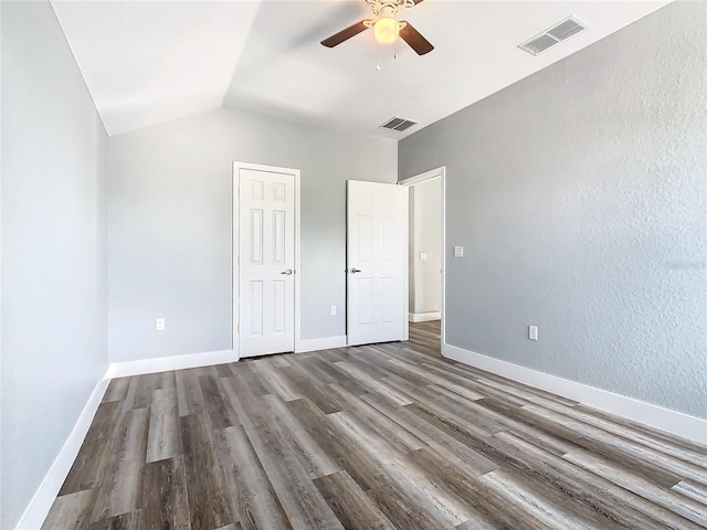 unfurnished bedroom with lofted ceiling, hardwood / wood-style flooring, and ceiling fan