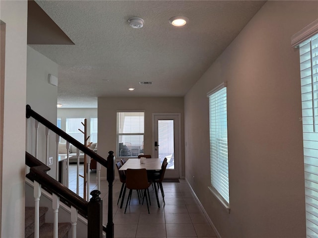 tiled dining area featuring a textured ceiling