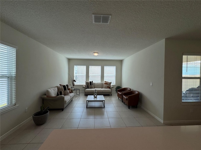 tiled living room featuring a textured ceiling