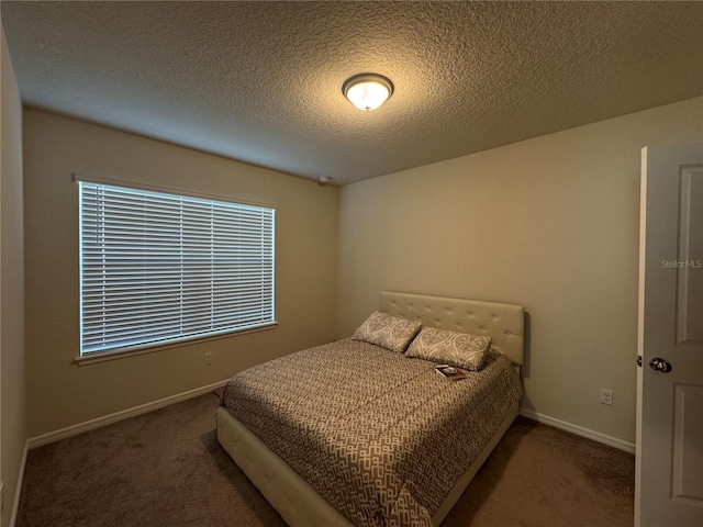 bedroom featuring a textured ceiling and carpet flooring