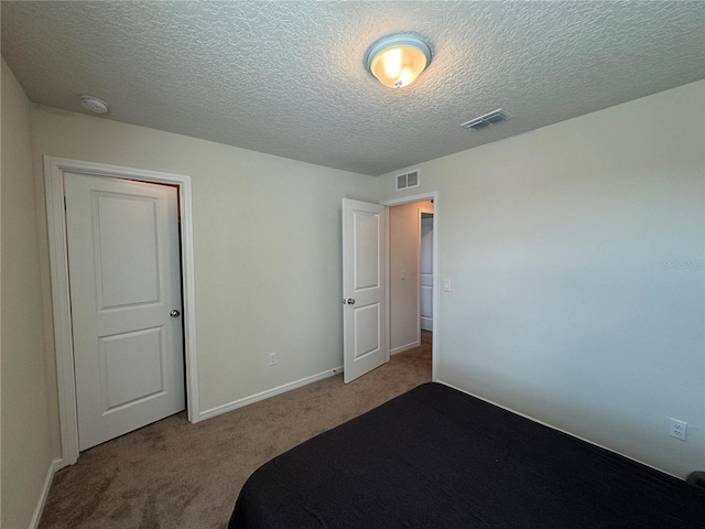 unfurnished bedroom featuring light carpet and a textured ceiling