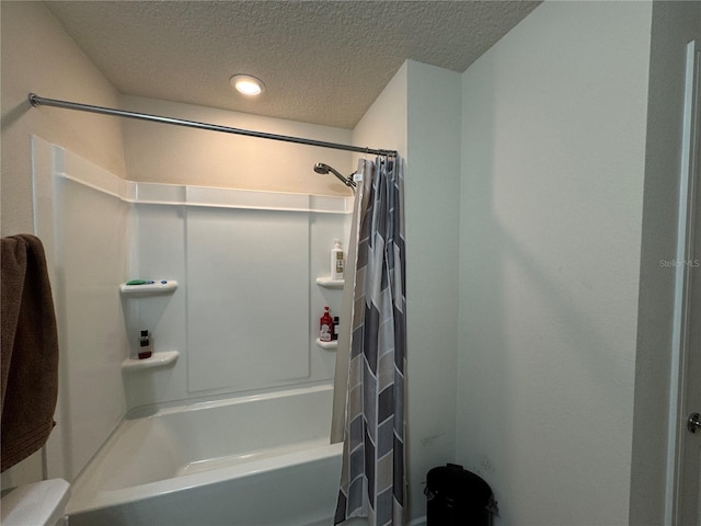 bathroom with a textured ceiling, shower / bathtub combination with curtain, and toilet