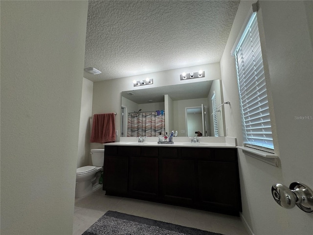 bathroom featuring a textured ceiling, vanity, toilet, and walk in shower