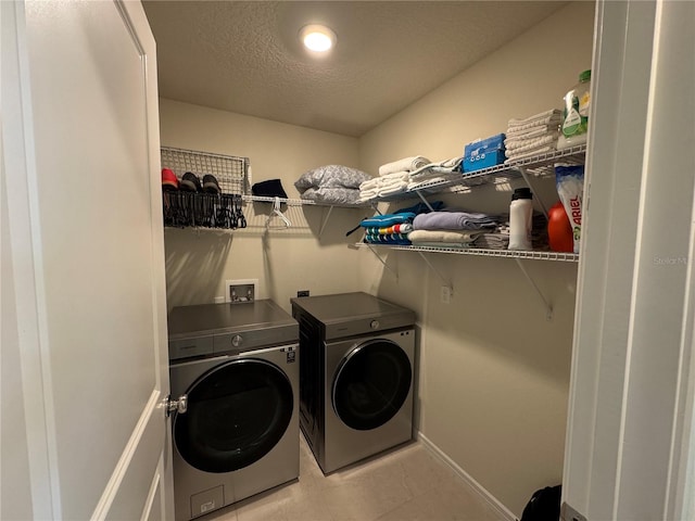 clothes washing area with a textured ceiling and washer and dryer