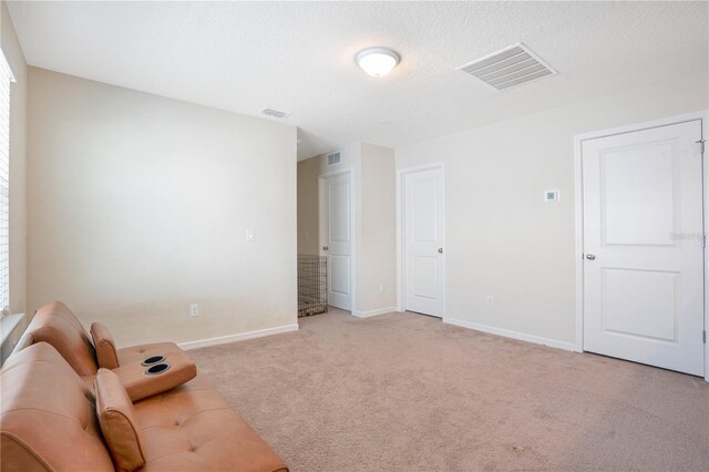 unfurnished room featuring light carpet and a textured ceiling