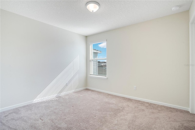 unfurnished room featuring light colored carpet and a textured ceiling