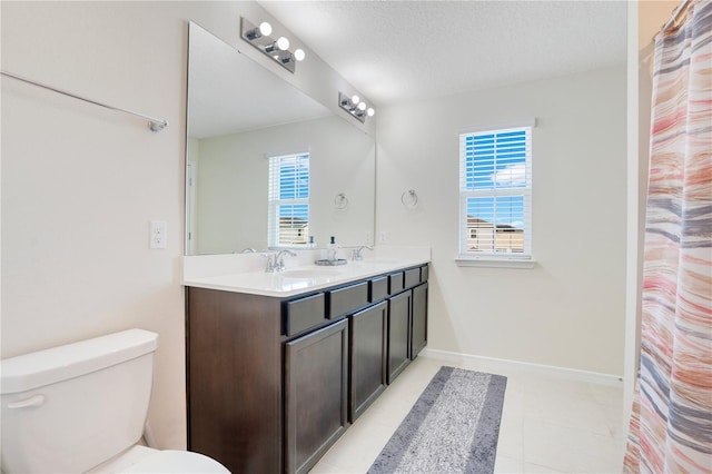 bathroom with vanity, a wealth of natural light, toilet, and a textured ceiling