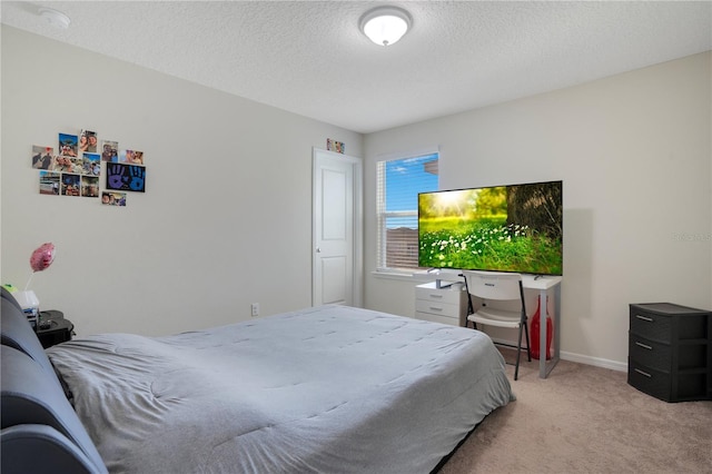 bedroom with light colored carpet and a textured ceiling