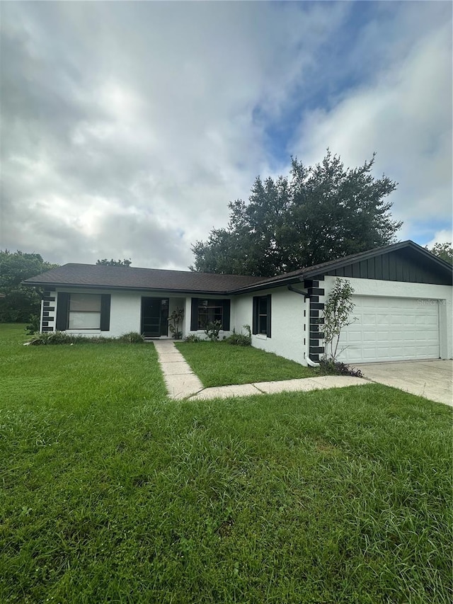 single story home with a garage and a front lawn