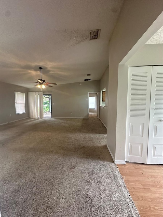 empty room featuring ceiling fan, light hardwood / wood-style floors, and a textured ceiling