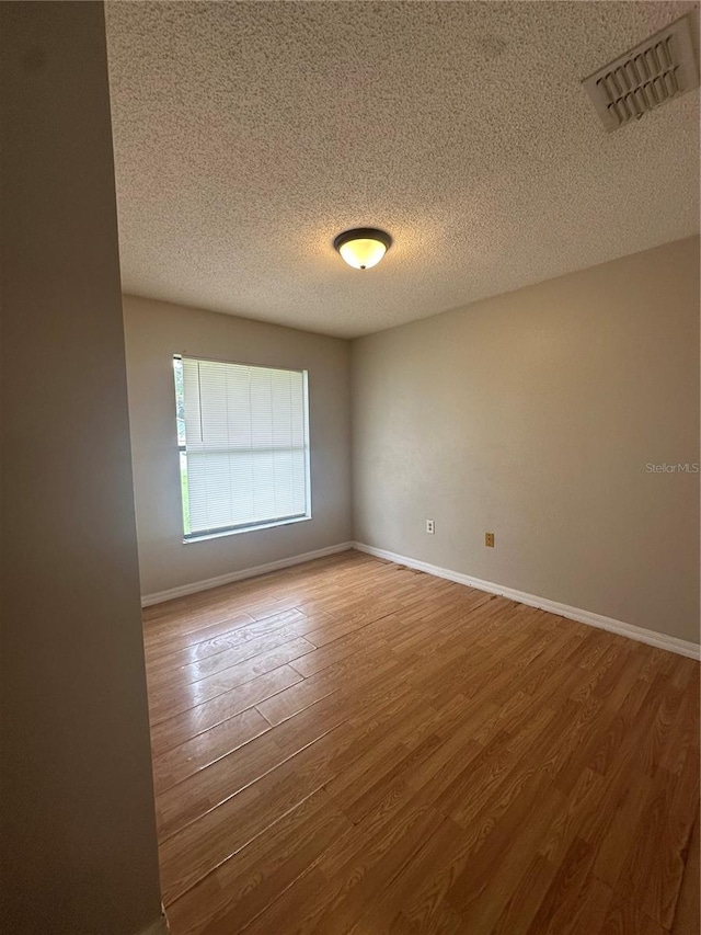 spare room with wood-type flooring and a textured ceiling