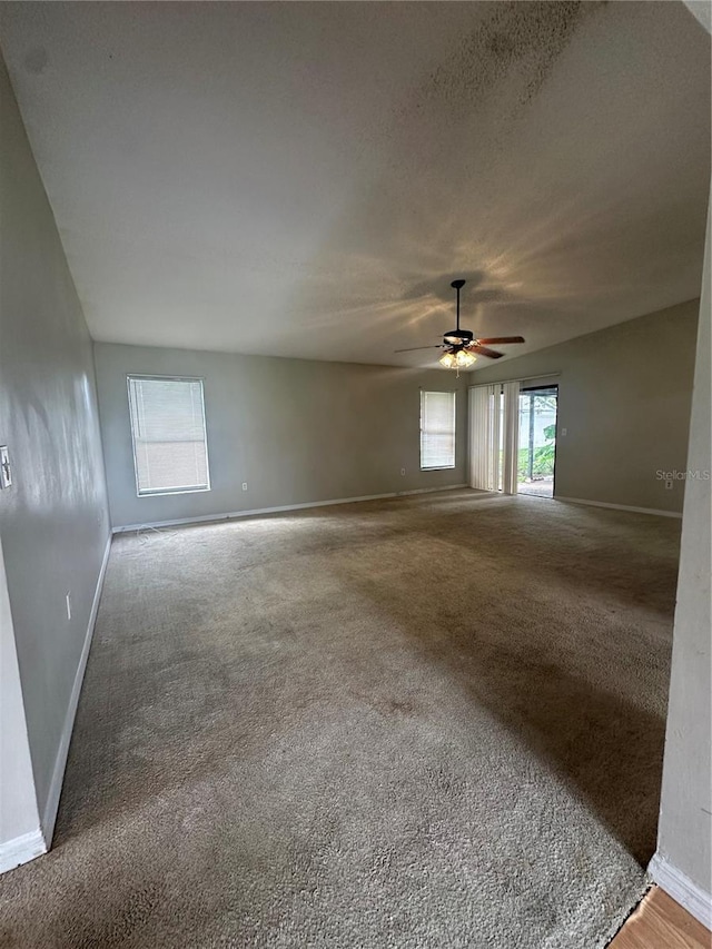 unfurnished room featuring carpet floors, plenty of natural light, and ceiling fan