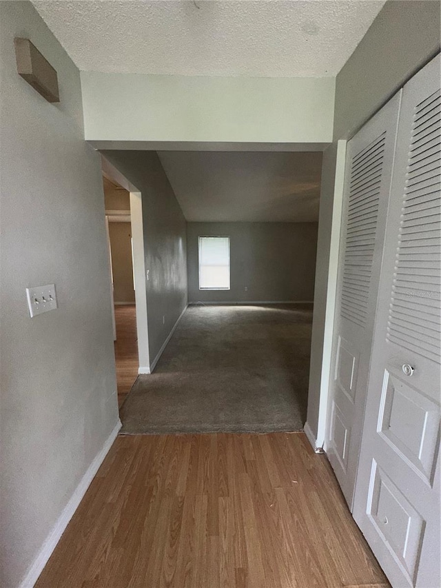 hallway with wood-type flooring and a textured ceiling