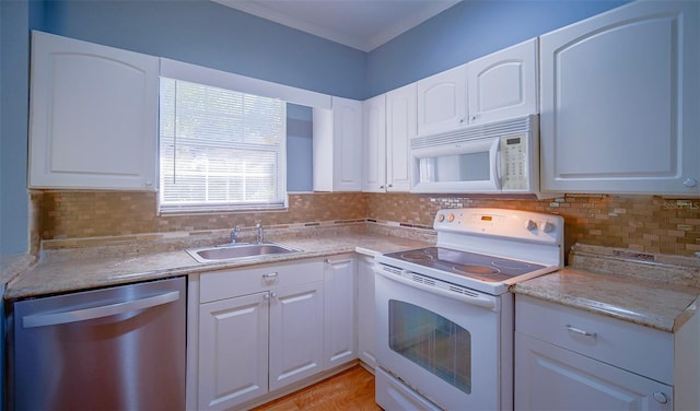 1501 NE 57th St, Ocala, FL 34479 - kitchen with white appliances, light countertops, white cabinets, and a sink