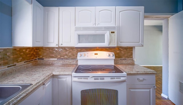 1501 NE 57th St, Ocala, FL 34479 - kitchen with a sink, white appliances, white cabinets, and tasteful backsplash