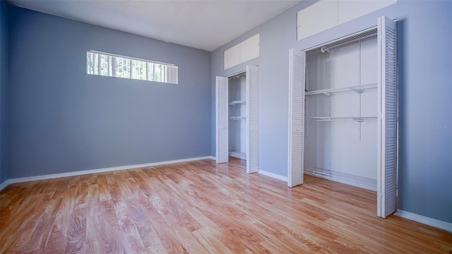 1501 NE 57th St, Ocala, FL 34479 - unfurnished bedroom with light wood finished floors, baseboards, and multiple closets