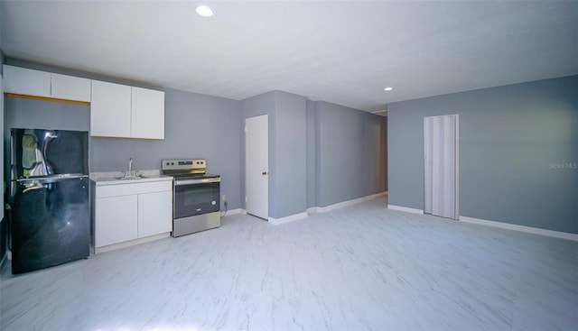 1501 NE 57th St, Ocala, FL 34479 - kitchen featuring freestanding refrigerator, a sink, stainless steel range with electric stovetop, light countertops, and white cabinets