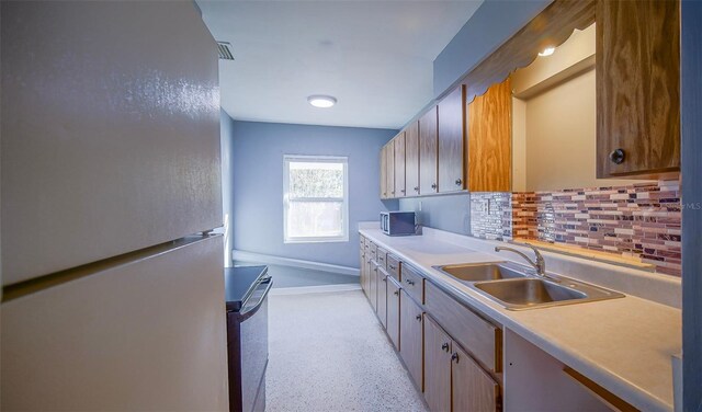 1501 NE 57th St, Ocala, FL 34479 - kitchen featuring a sink, freestanding refrigerator, stainless steel microwave, range, and tasteful backsplash