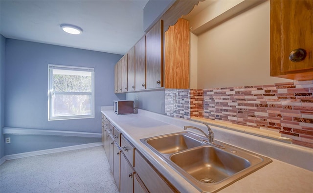 1501 NE 57th St, Ocala, FL 34479 - kitchen with backsplash, light countertops, baseboards, and a sink