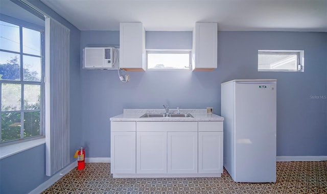 1501 NE 57th St, Ocala, FL 34479 - clothes washing area with baseboards, light floors, a wall unit AC, and a sink