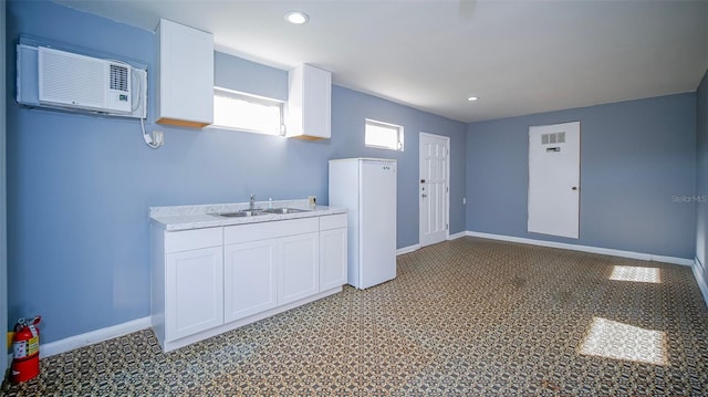 1501 NE 57th St, Ocala, FL 34479 - kitchen with a sink, white cabinets, baseboards, an AC wall unit, and recessed lighting